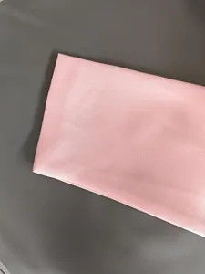 Detailed close-up of soft pink fabric texture for women's elegant blazer apparel.