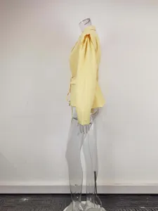 Side detail view of a elegant yellow wrap blazer featuring chic tied waist and puff sleeves.