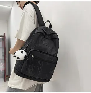 Detail view of the stylish black casual backpack featuring fresh bamboo print and panda charm.
