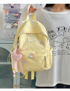 Sac à dos matelassé jaune avec écussons d'étoiles et pendentif coeur pour l'école.