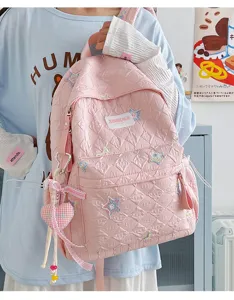 Sac à dos d'école matelassé rose pour étudiants avec broderie d'étoiles et pendentif.