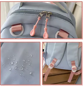 Detailed view of the light blue student backpack featuring pink straps and waterproof fabric.