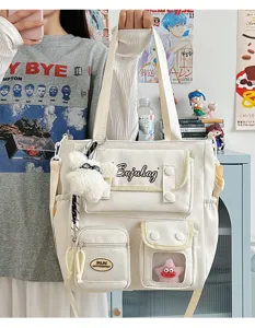 Detailed view of the Japanese style multi-pocket canvas shoulder bag with cute bear charm.