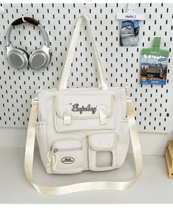 Japanese style white canvas messenger bag with multi pockets and contrast strap.