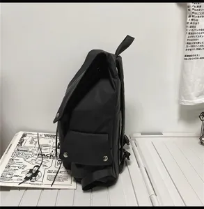 Seitenansicht Detail des minimalistischen schwarzen Rucksacks mit Klappentasche.