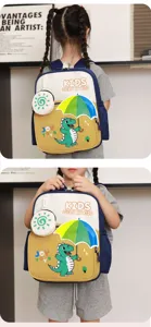 Detailansicht des niedlichen Dino Kinderrucksacks mit passender Tasche und Schirm-Grafik.
