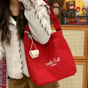 Detailansicht der roten Stofftasche, lässiges Canvas-Design mit weißer Stickerei, ideal.