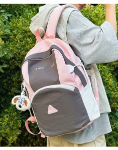 Cute color-block student backpack detail, pink and grey travel school bag with charm.