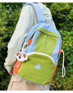 Cute color-block student backpack for daily school and travel with dog pendant and large capacity.