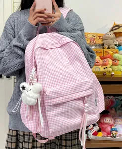 Pink gingham school backpack detail, cute canvas student daypack with plush pendant and cords.