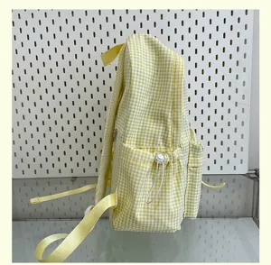 Side detail view of the yellow white gingham backpack featuring a handy side pocket and drawstring.