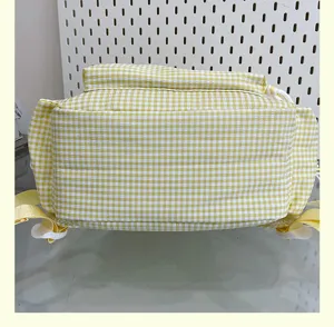 Yellow plaid backpack detail showing bottom structure and sturdy adjustable shoulder straps.