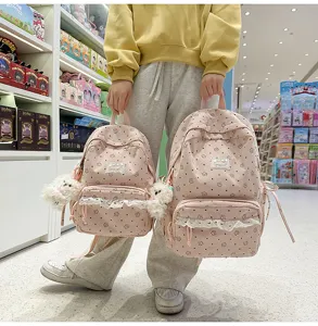 Detailed view of cute pink corduroy school backpack with floral pattern and delicate lace trim.