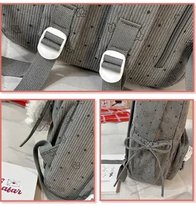 Grey corduroy backpack detail view featuring cute star print, bow knot and white buckles.