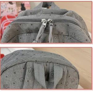 Detail view of the stylish grey corduroy backpack showcasing cute floral pattern and durable zippers.