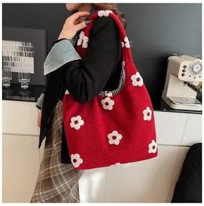Vue détaillée du sac cabas duveteux rouge à fleurs, porté élégamment sur l'épaule au quotidien.