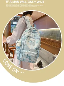 Detail shot of the blue bamboo leaf print backpack with multi-pockets and cute bear pendant.