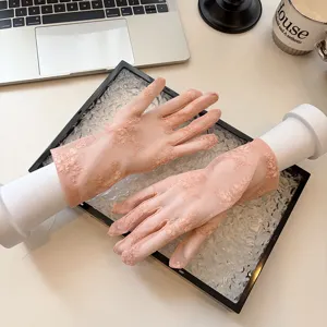 Detailed view of women's short lace sunscreen gloves with delicate floral mesh pattern.