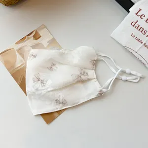Detailansicht der doppelstufigen Mesh-Staubmaske mit süßem Schleifen-Blumenmuster und verstellbar.