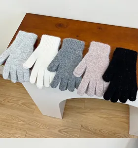 Detailed close-up showing multiple colors of fluffy winter knitted gloves arranged neatly.