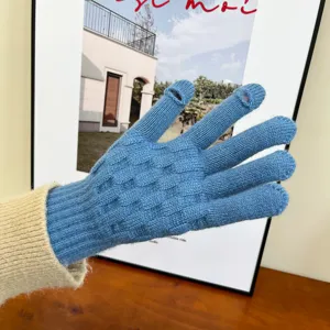 Close-up view of blue knitted winter touchscreen gloves showing thumb and index finger openings.