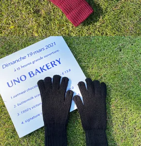 Primer plano de guantes de invierno de punto negro sobre hierba verde al aire libre.