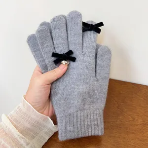 Grey knitted gloves detail, cozy winter handwear with elegant black velvet bows accent.