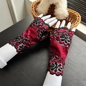 Detailed shot of fashionable two-tone lace fingerless gloves with red and black floral pattern for women.