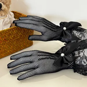Detail view of black fishnet lace gloves featuring elegant satin bows and faux pearls.