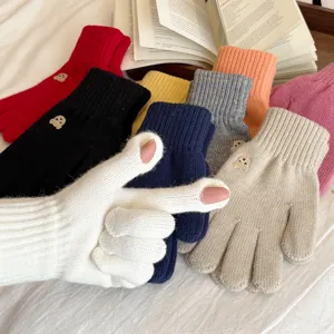 Close-up detail of cute bear embroidered knit touch screen gloves in vibrant colors.