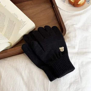 Detailed shot of black knit gloves featuring a cute embroidered bear, soft winter warm mittens.