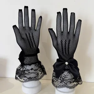 Close-up of elegant black lace fishnet gloves featuring a delicate bow and pearl detail.
