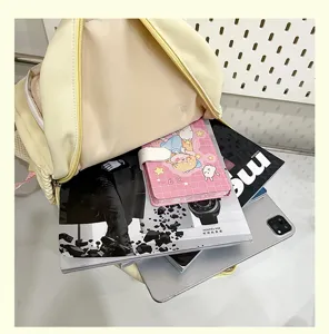 Cute Japanese style yellow canvas backpack detail showing capacity with books and tablet.