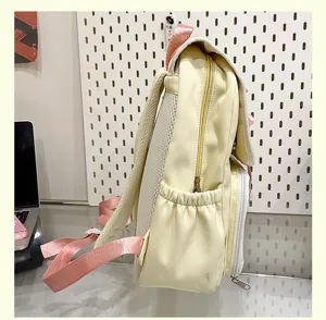 Detailed side view of yellow and pink casual student backpack with mesh shoulder straps.