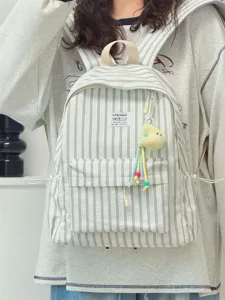 Detailed view of the stylish striped backpack featuring a cute plush pendant and roomy design.