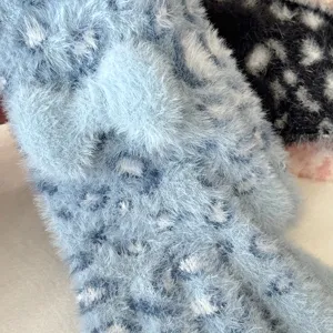 Close-up detail of fluffy faux mink fur winter gloves featuring soft leopard texture and bow.