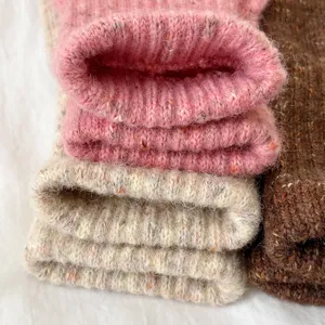 Close-up detail of cozy speckled knit winter gloves, soft textured ribbed cuffs for warmth.