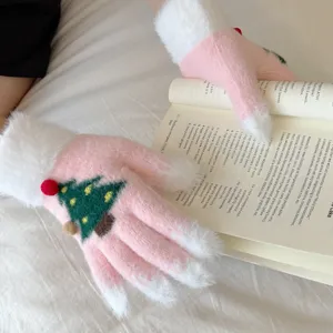 Close-up detail of cute pink plush Christmas tree touchscreen winter warm gloves texture.