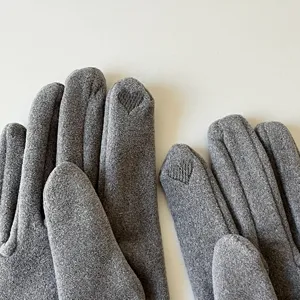 Detailed close-up of grey women's thermal touch screen gloves with cute heart fingertip embroidery.