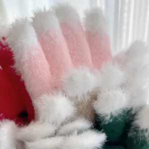 Close-up of fluffy winter touch screen gloves, thick warm material with pom poms for Christmas.