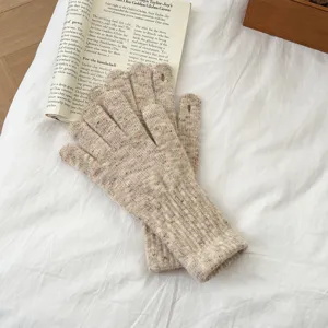 Detail shot of women winter oatmeal speckled knit touchscreen gloves on white bedsheet background.