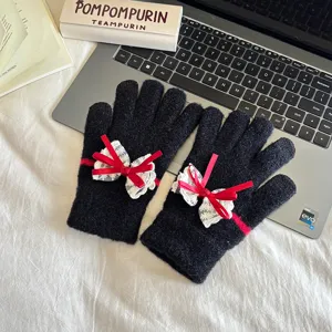 Women's black knit touch screen gloves featuring red bow lace design, warm winter accessories.