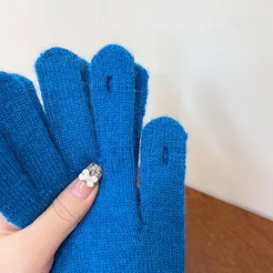 Close-up detail of blue winter knitted touchscreen gloves featuring convenient finger slot design.