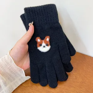 Close-up detail shot of black knit winter gloves featuring cute cartoon puppy patch design.