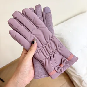Primo piano di guanti invernali caldi touch screen con grazioso design a fiocco e fodera morbida.