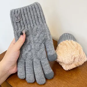 Detail view of grey knitted touchscreen gloves featuring warm fleece lining and stylish cuff tag.