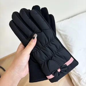 Primo piano dei guanti invernali touch screen caldi con un grazioso dettaglio a fiocco e fodera.