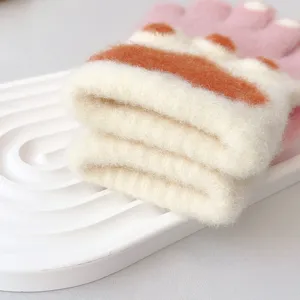 Detail view of cozy knit gloves with cute paw print, soft winter warm detail display.