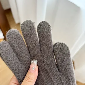 Detailed shot of winter warm knit gloves for women, dark grey full finger touch screen design.