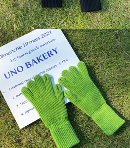 Detalle de guantes de invierno de punto verde, tejido cálido de lana con puño largo.